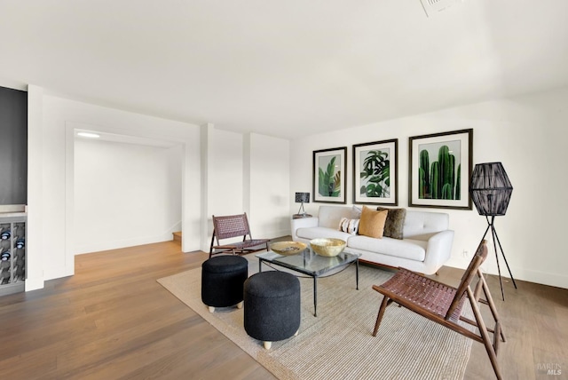 living area with visible vents, baseboards, and wood finished floors