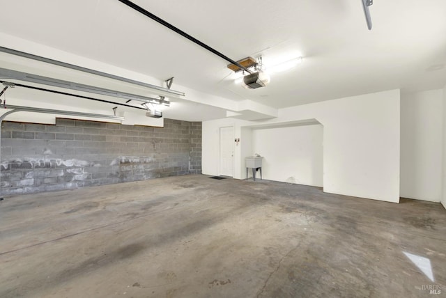 garage featuring a garage door opener and a sink