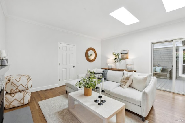 living room with baseboards, a skylight, crown molding, and light wood finished floors