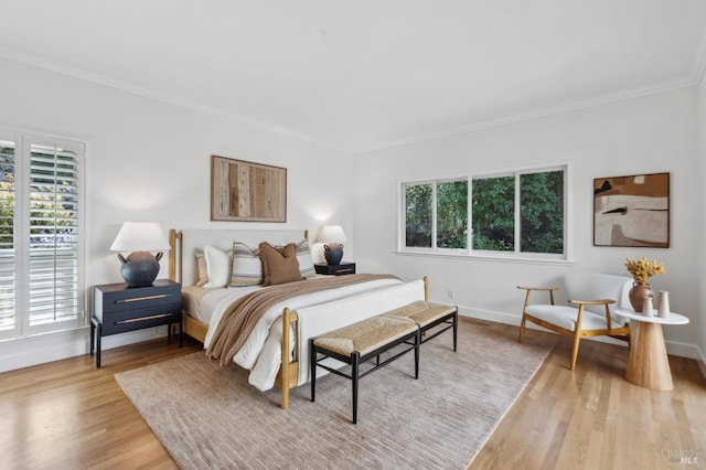 bedroom with baseboards, multiple windows, wood finished floors, and ornamental molding