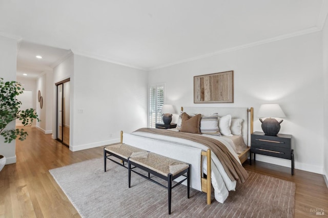 bedroom featuring recessed lighting, crown molding, baseboards, and wood finished floors