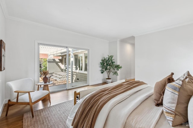 bedroom with ornamental molding, wood finished floors, and access to outside