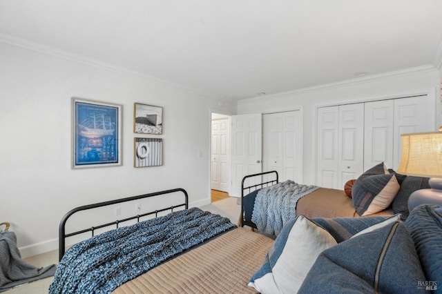 bedroom with crown molding, baseboards, and two closets