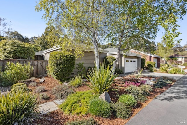 view of front of home featuring an attached garage, driveway, and fence