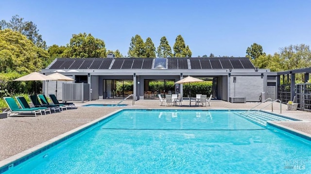 community pool with a patio and fence