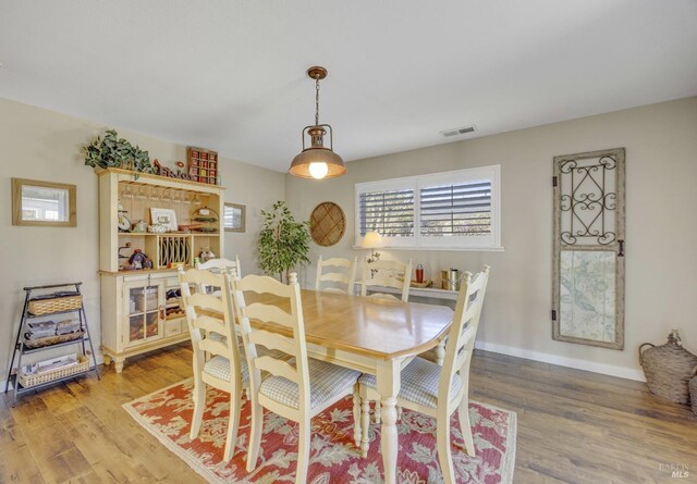 dining area featuring visible vents, light wood-type flooring, and baseboards