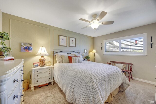 bedroom with light colored carpet, baseboards, and ceiling fan