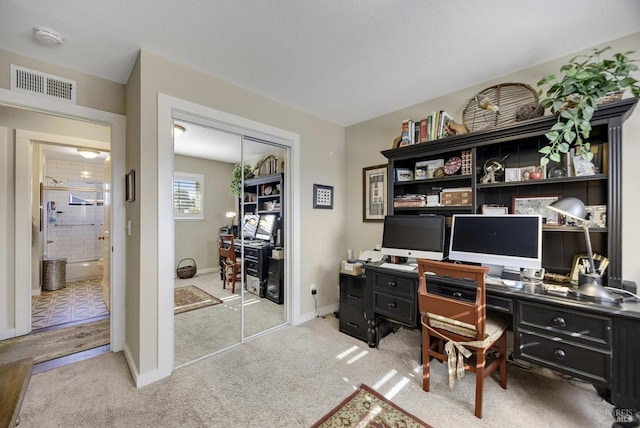 carpeted office featuring baseboards and visible vents