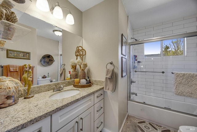 bathroom featuring enclosed tub / shower combo, toilet, vanity, and baseboards