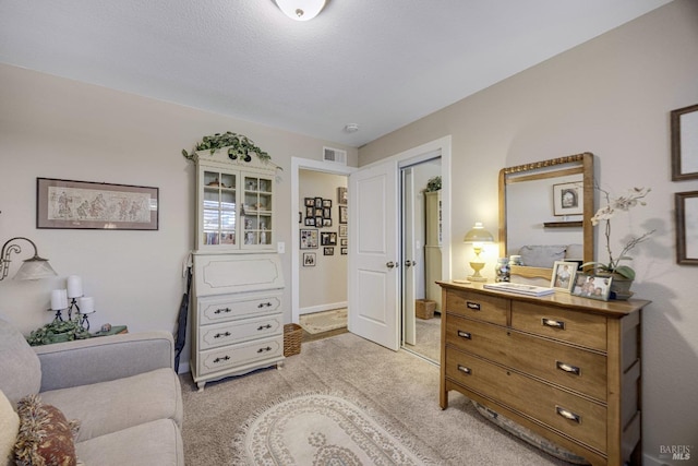 living area featuring visible vents and light carpet