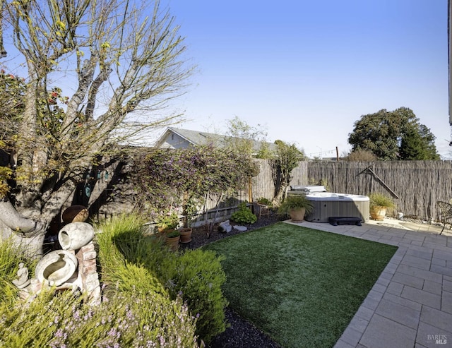 view of yard with a fenced backyard, cooling unit, a hot tub, and a patio