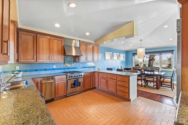 kitchen with stainless steel range, a sink, backsplash, brown cabinetry, and wall chimney range hood