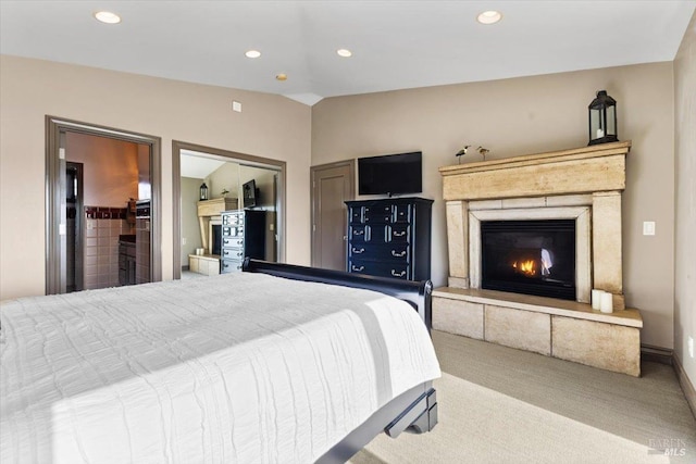 carpeted bedroom featuring recessed lighting, lofted ceiling, and a glass covered fireplace