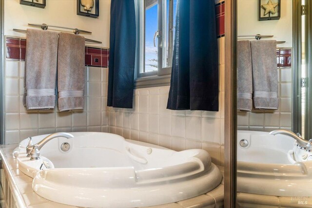 bathroom featuring a bath and tile walls