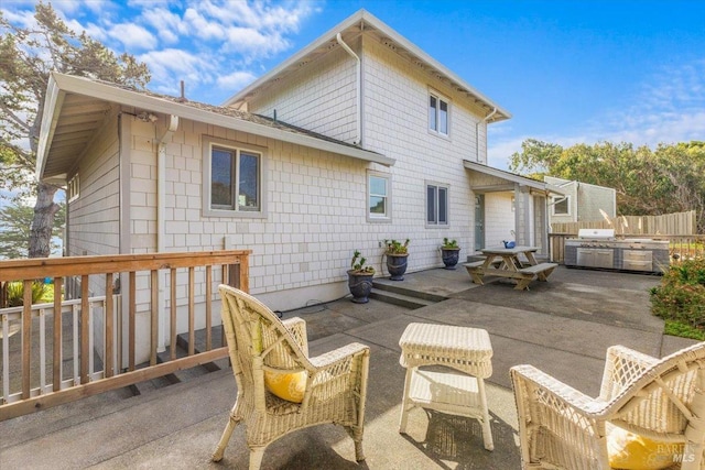 rear view of house featuring an outdoor kitchen, a patio, and fence