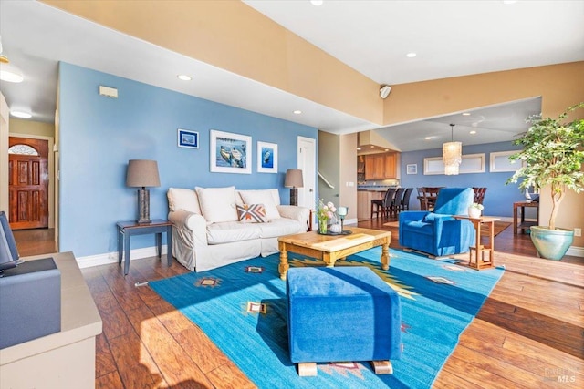 living room with recessed lighting, baseboards, vaulted ceiling, and hardwood / wood-style flooring