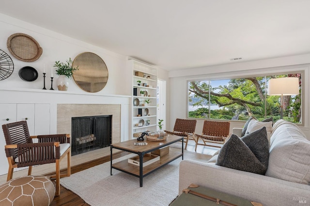 living room with visible vents, wood finished floors, and a fireplace