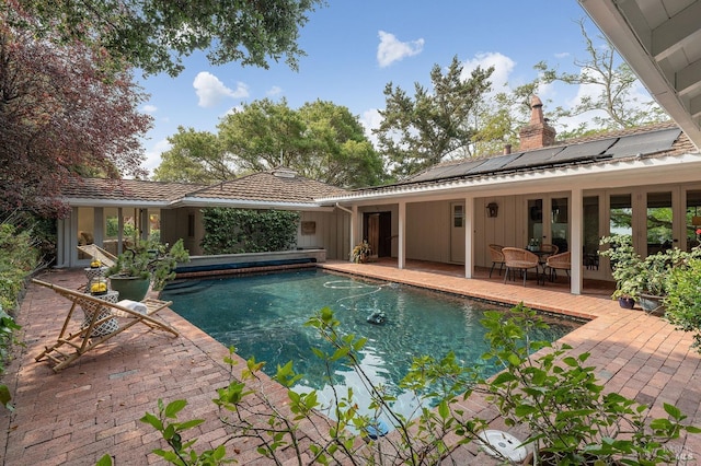 pool with french doors and a patio area