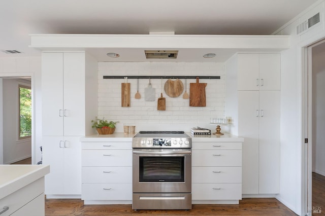 kitchen featuring decorative backsplash, stainless steel electric range, white cabinetry, and light countertops