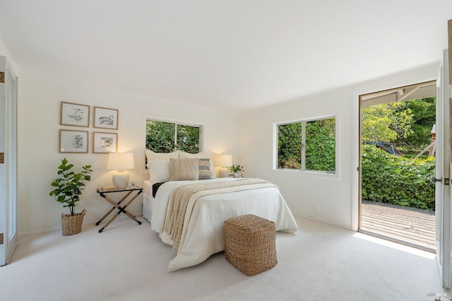 bedroom with multiple windows, carpet flooring, and access to outside