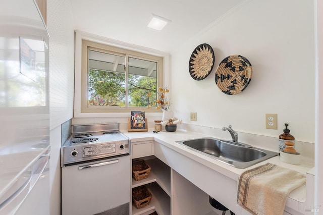 kitchen featuring a sink, range with electric cooktop, white cabinets, and light countertops