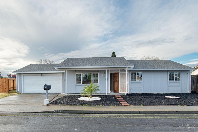 ranch-style house featuring fence, a garage, driveway, and roof with shingles