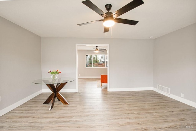 spare room featuring light wood-type flooring, baseboards, and visible vents