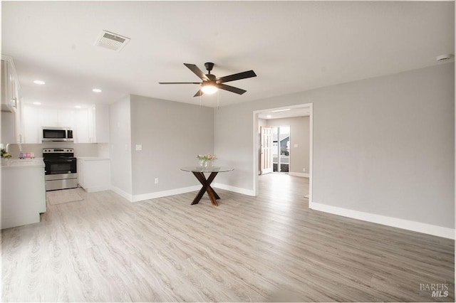 unfurnished living room with light wood finished floors, visible vents, and baseboards