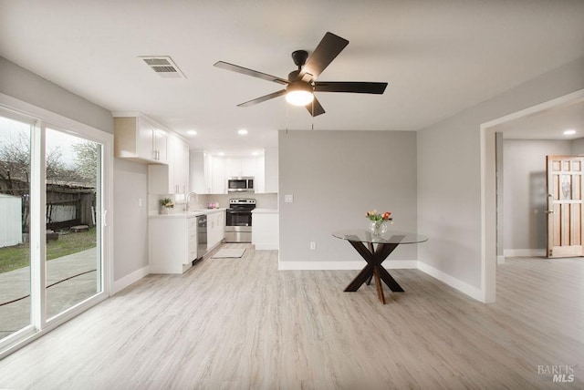 kitchen with visible vents, light wood-type flooring, a sink, appliances with stainless steel finishes, and light countertops