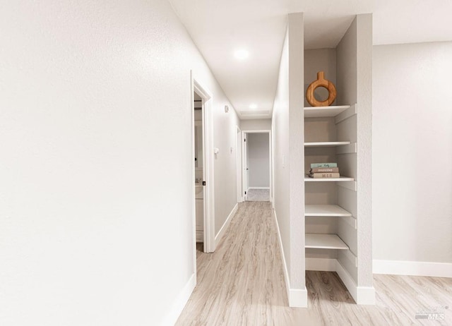 hall with wood finished floors and baseboards