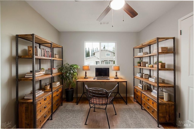 office space with visible vents, baseboards, wood finished floors, and a ceiling fan