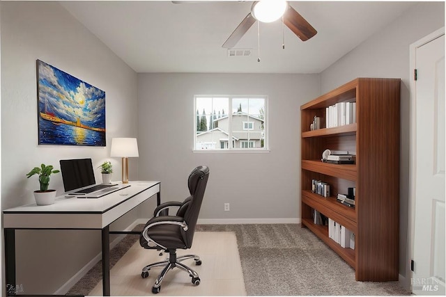 home office featuring visible vents, baseboards, a ceiling fan, and carpet flooring