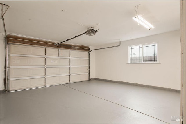 garage with baseboards and a garage door opener