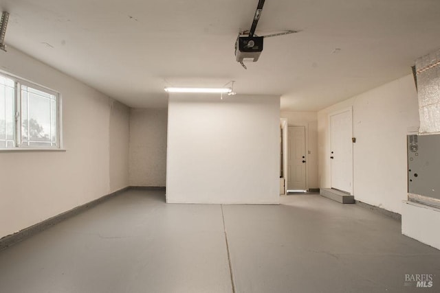 garage with a garage door opener and baseboards