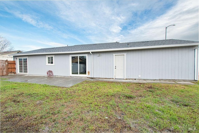 back of house featuring a lawn, a patio, and fence