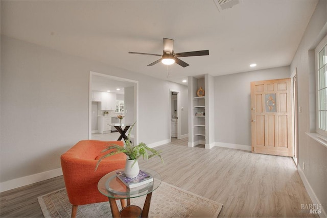 living area featuring a ceiling fan, baseboards, visible vents, light wood finished floors, and recessed lighting