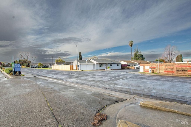 view of street with curbs, a residential view, and street lights