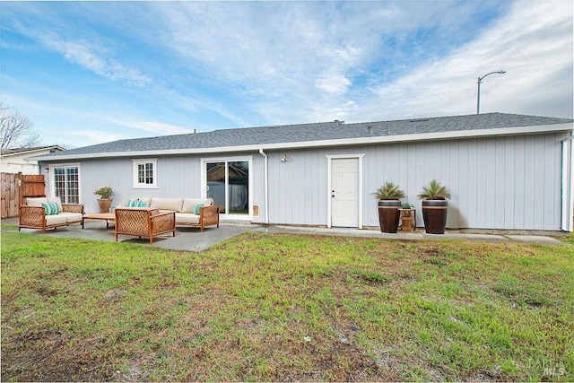 rear view of house featuring fence, roof with shingles, outdoor lounge area, a yard, and a patio area