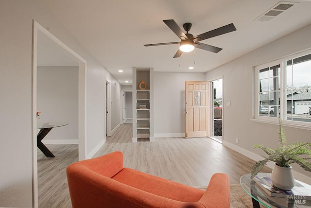 living area featuring visible vents, light wood-style flooring, a ceiling fan, recessed lighting, and baseboards