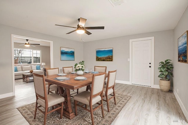 dining area featuring light wood-type flooring, visible vents, and baseboards