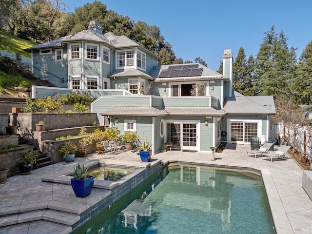 15 Kingswood Dr, Petaluma, CA 94952 - back of property with a balcony, roof mounted solar panels, a chimney, a patio, and a fenced backyard