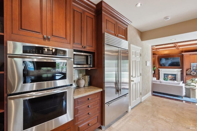 15 Kingswood Dr, Petaluma, CA 94952 - kitchen with stainless steel appliances, brown cabinetry, light stone countertops, open floor plan, and light tile patterned floors