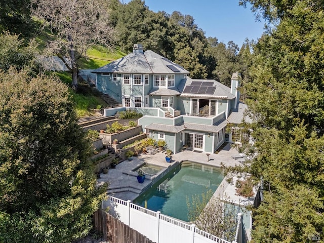 15 Kingswood Dr, Petaluma, CA 94952 - back of property with a chimney, a fenced backyard, roof mounted solar panels, and a patio area