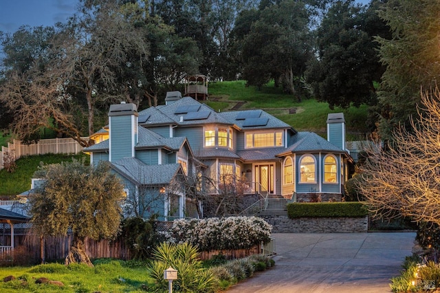 15 Kingswood Dr, Petaluma, CA 94952 - rear view of house featuring a chimney, solar panels, and stone siding