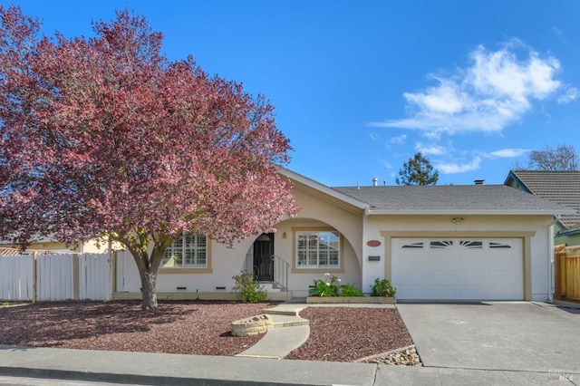 view of front facade featuring fence, an attached garage, stucco siding, concrete driveway, and crawl space