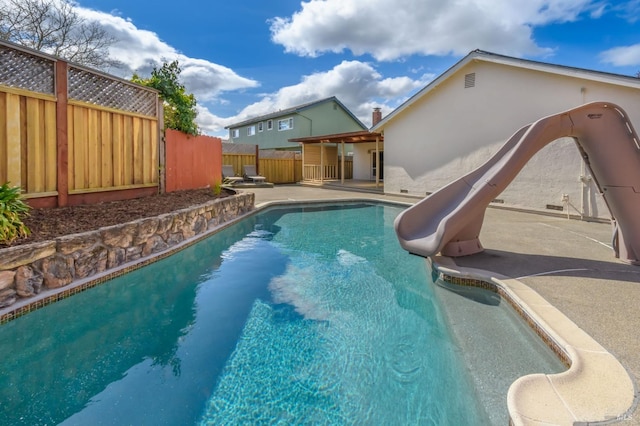 view of pool with a patio, a fenced backyard, a fenced in pool, and a water slide