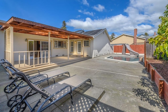 back of property with a fenced in pool, a fenced backyard, stucco siding, and a patio area