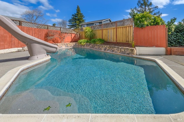 view of swimming pool with a fenced in pool, a water slide, and a fenced backyard