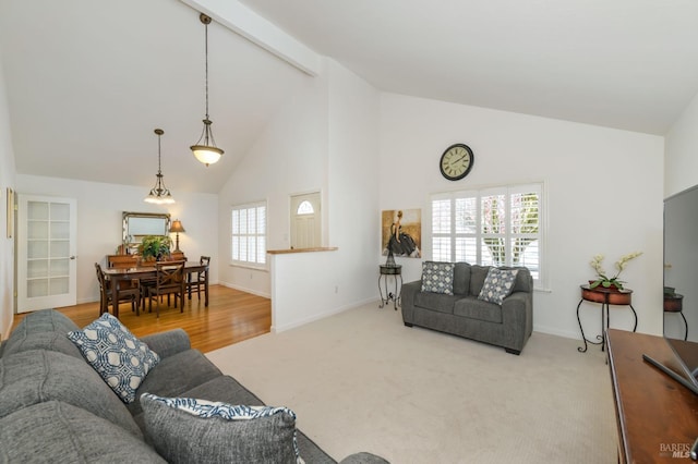 carpeted living room with beamed ceiling, baseboards, and high vaulted ceiling