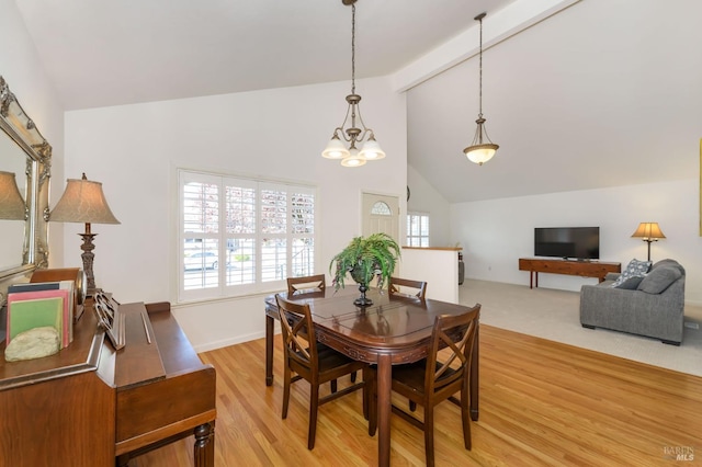 dining space with beam ceiling, high vaulted ceiling, and light wood-type flooring